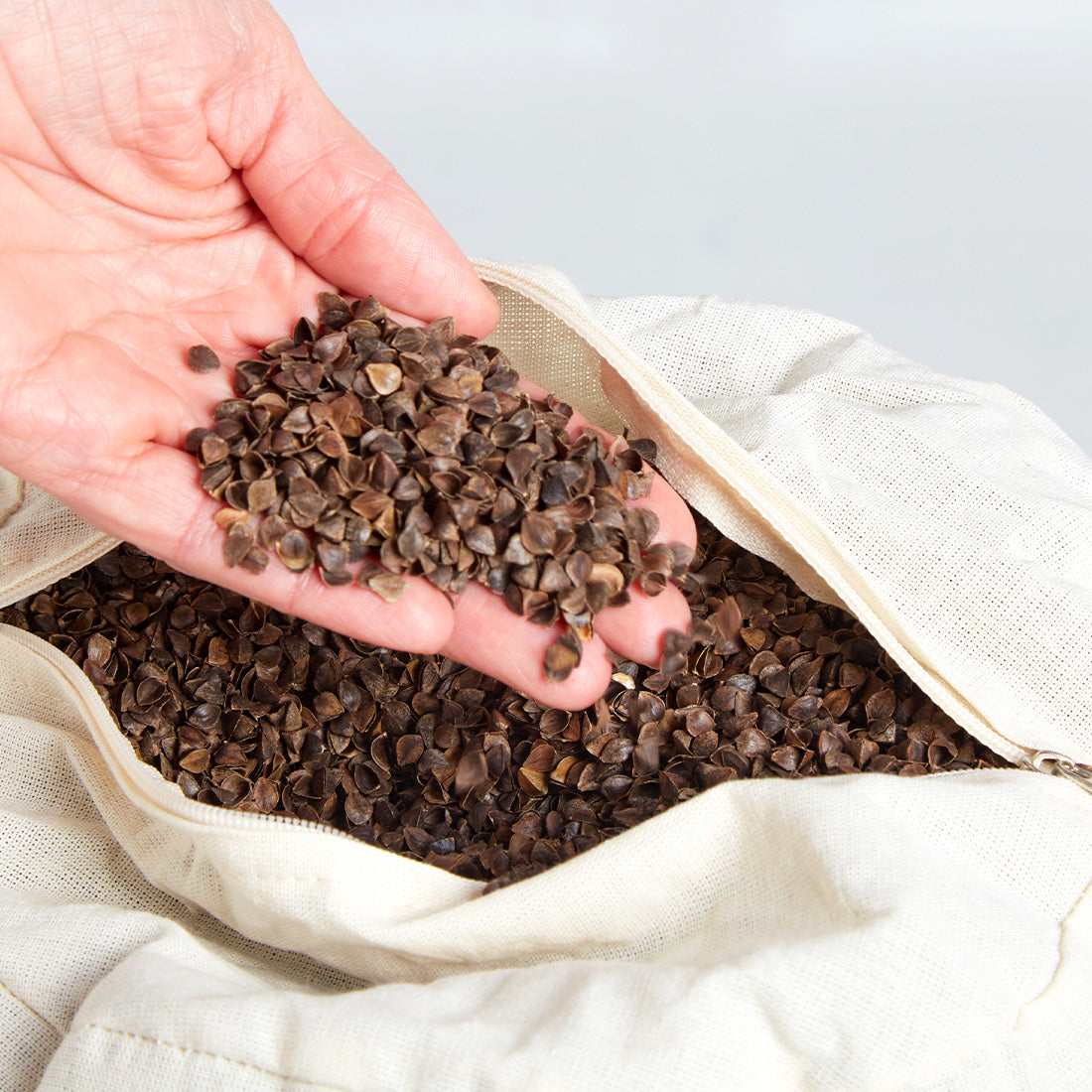 Relleno de cáscara de trigo sarraceno y funda estampada azul para bolster redondo Sukha Argentina.