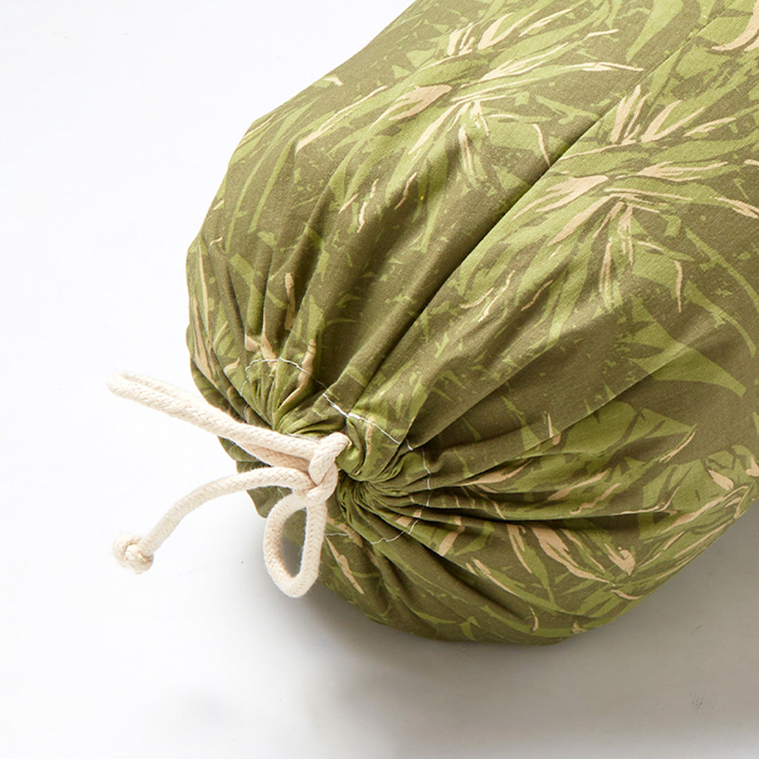 Funda de bolster redondo estampado en verde con relleno de cáscara de trigo sarraceno de Sukha Argentina.