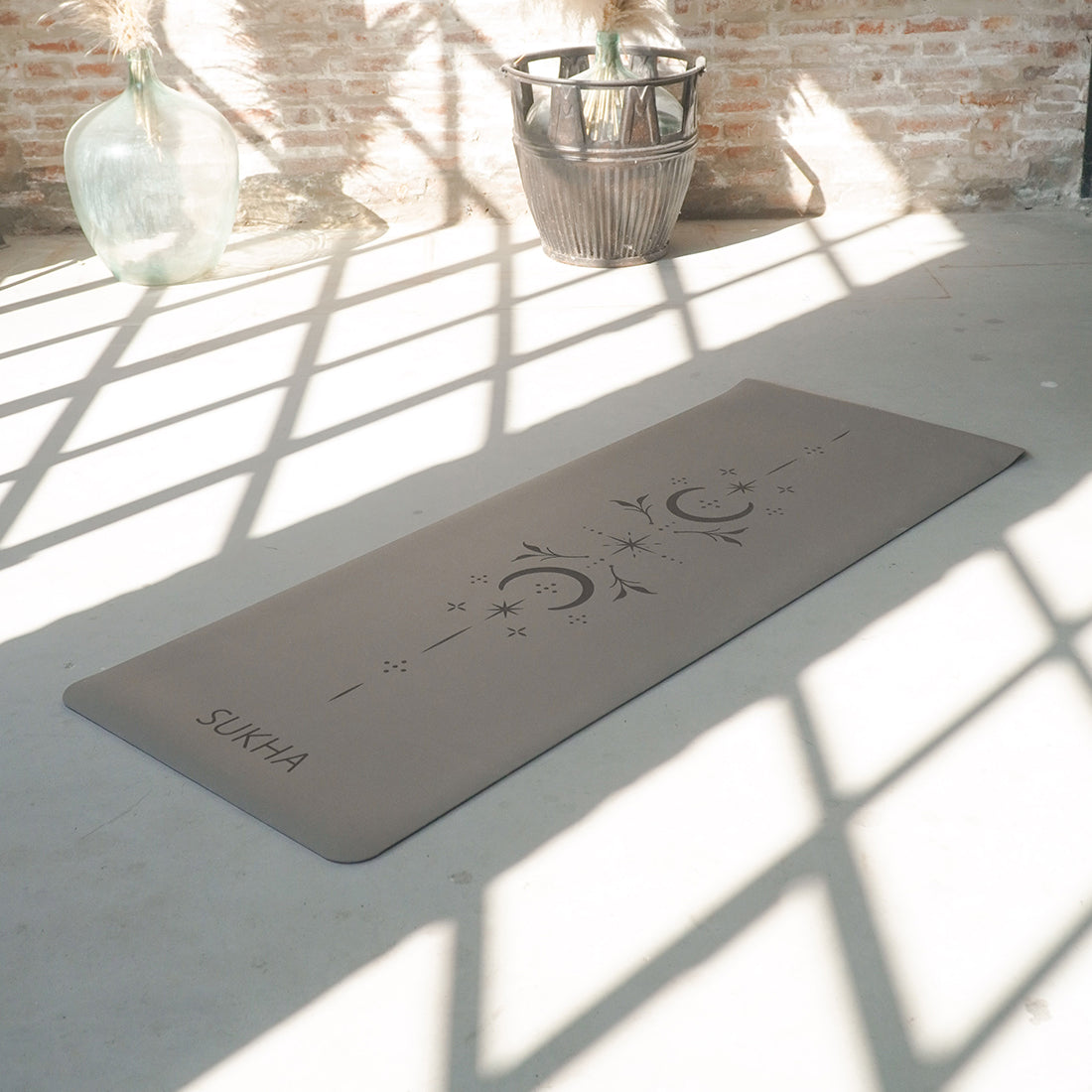Estera de yoga superior Sukha Argentina DOT de 5 mm sobre superficie, con diseño de puntos y color chai.