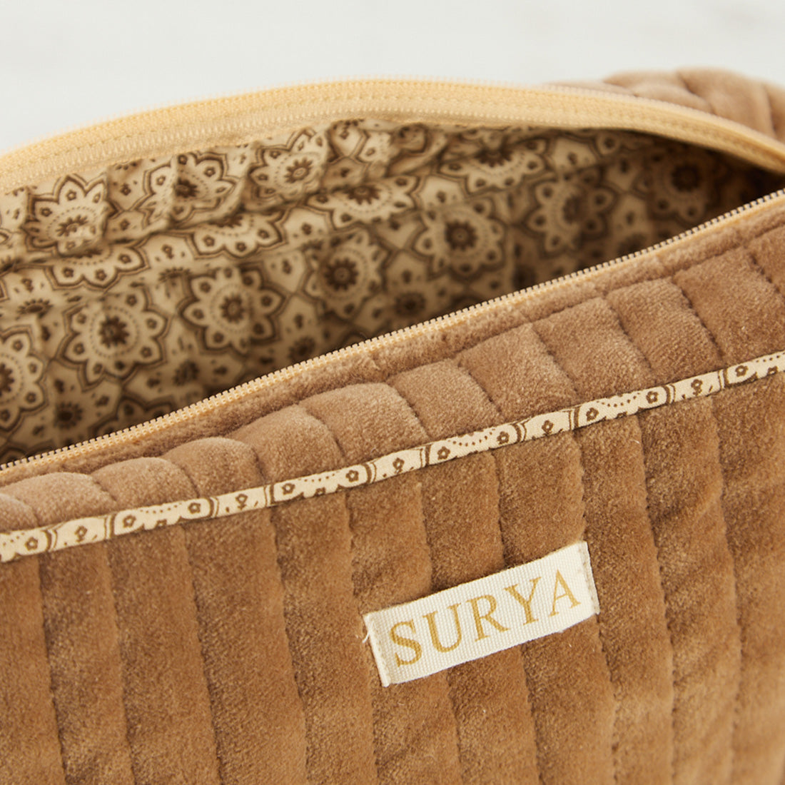 Neceser de terciopelo Velvet Surya de Sukha Argentina, con cierre y compartimentos, en color gris suave.