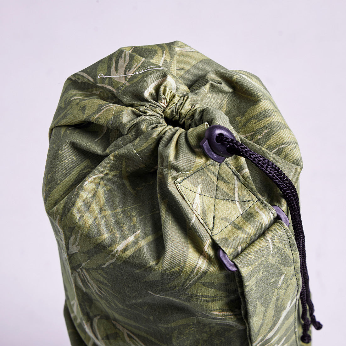Bolso portamonedas de gabardina con correa ajustable y estampado verde, de la marca Sukha Argentina.
