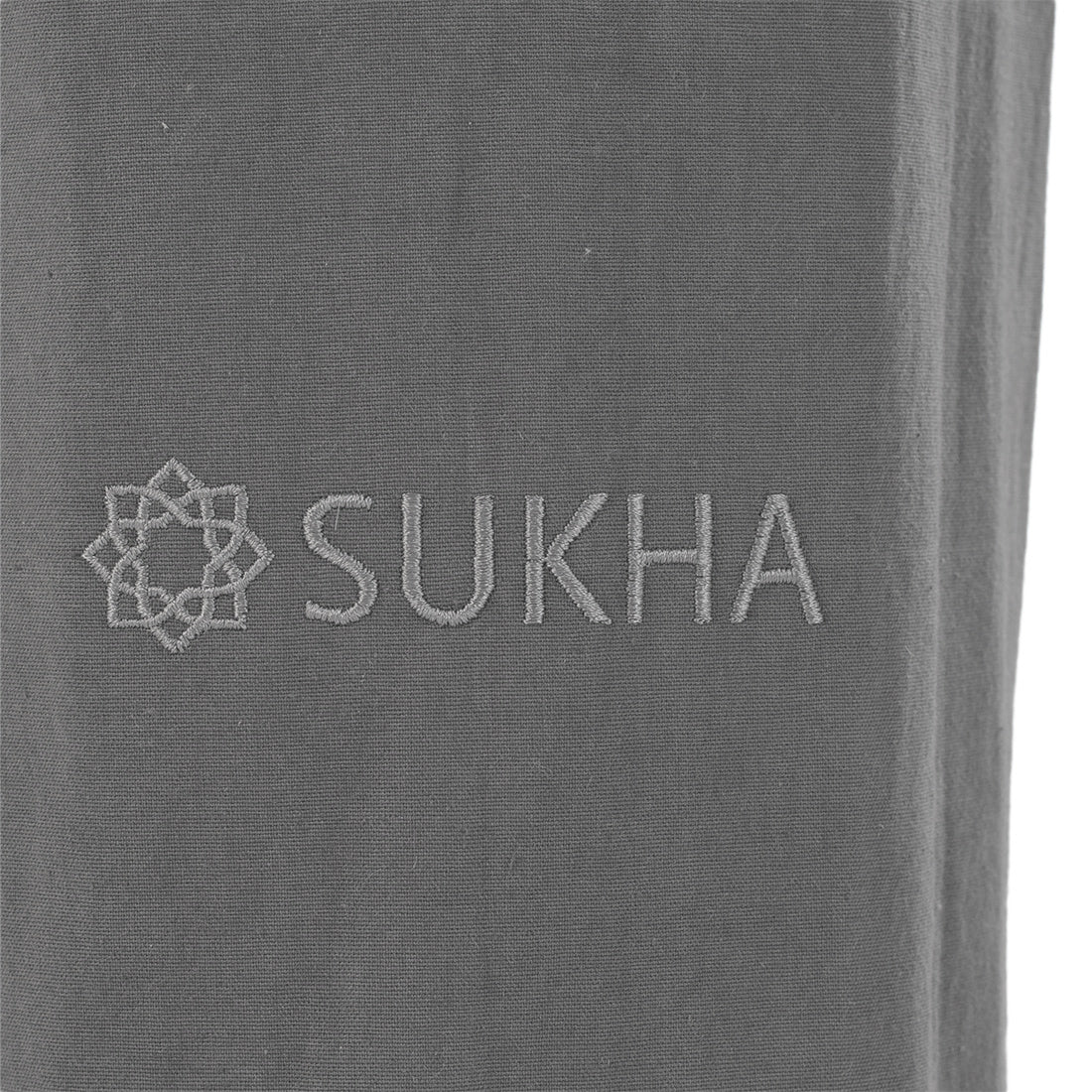 Bolso portamats Sukha Argentina con estampado gráfico y bordado en tonos gris, de tamaño compacto y diseño elegante.