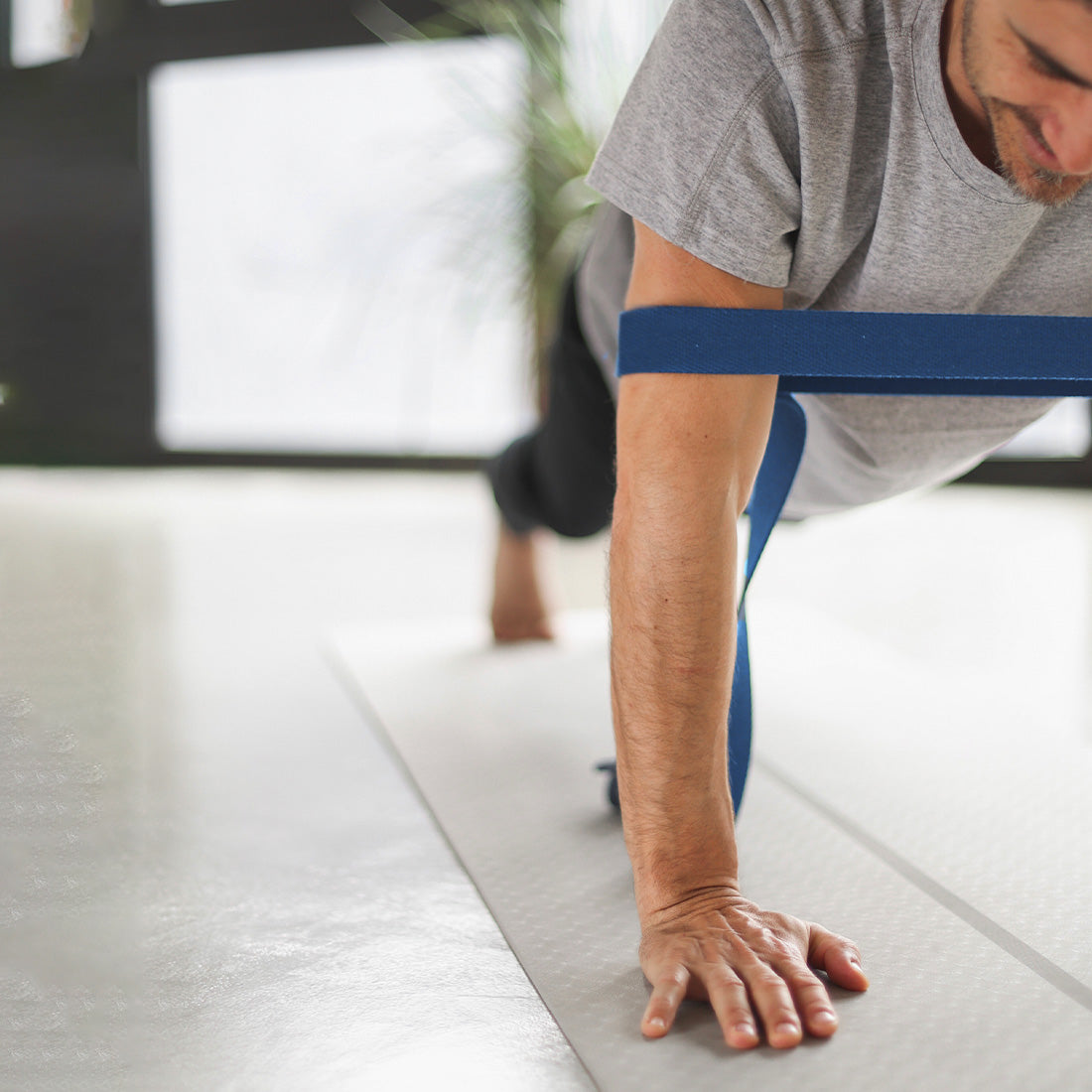 Cinto de yoga azul de la marca Sukha Argentina, mostrando su uso en una postura de estiramiento.